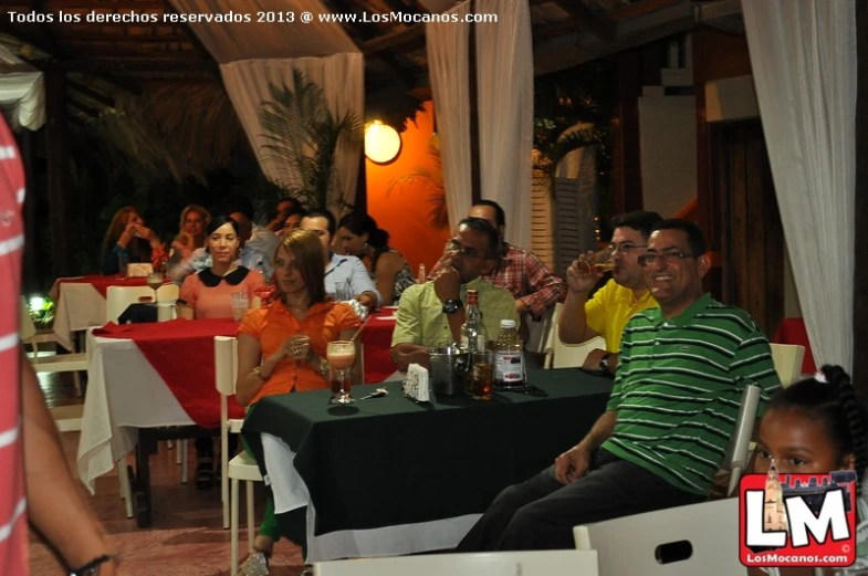 a large group of people enjoying drinks at a social gathering