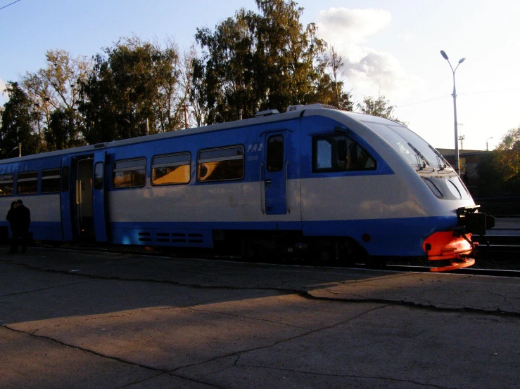the blue and white train is stopped at the station