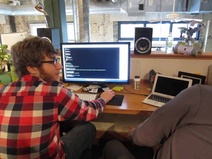 a man is working on a computer and looking at the screen