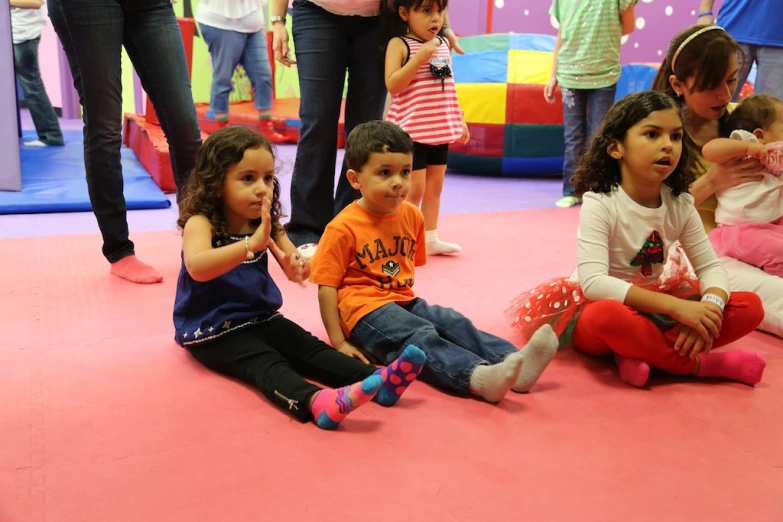 children sitting on the floor of a child's play area