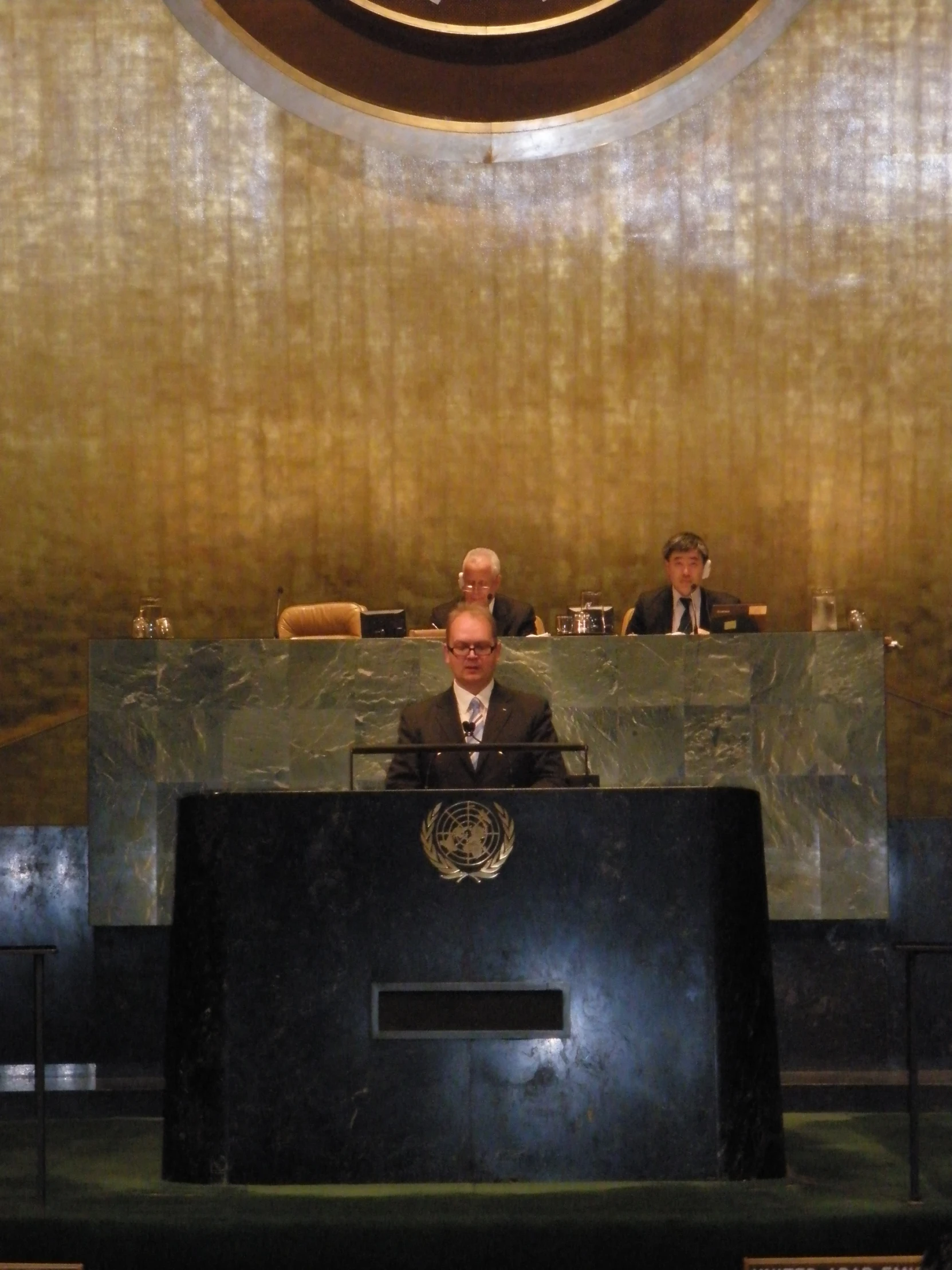 several people are sitting at desks in a large room