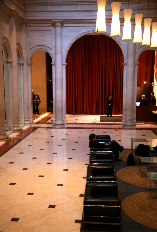 the inside of a large building with a long row of empty black chairs