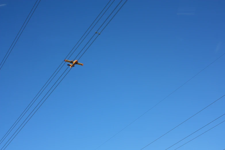 an airplane is flying high above the electrical line