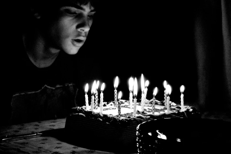 a man looking at a cake with candles