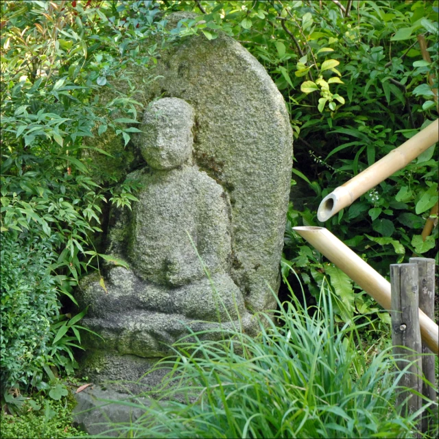 the buddha statue is sitting next to two poles