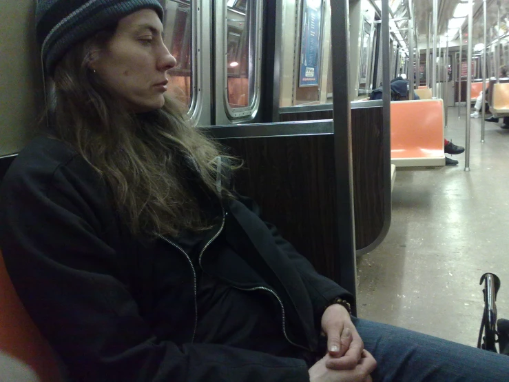 woman wearing a beanie sitting on a subway