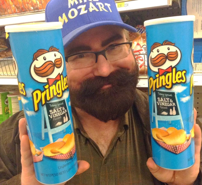 a man holding up two cup of chips