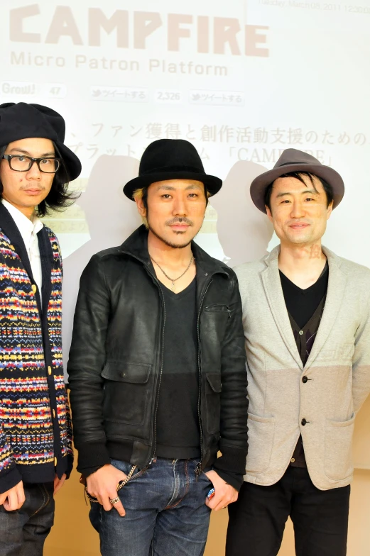 three men are wearing black hats and jackets