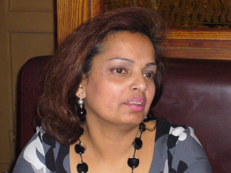 a woman sitting in front of a brown wooden table