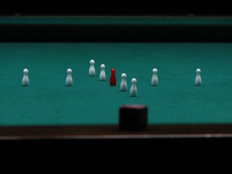 a pool table with a green table and several white pins