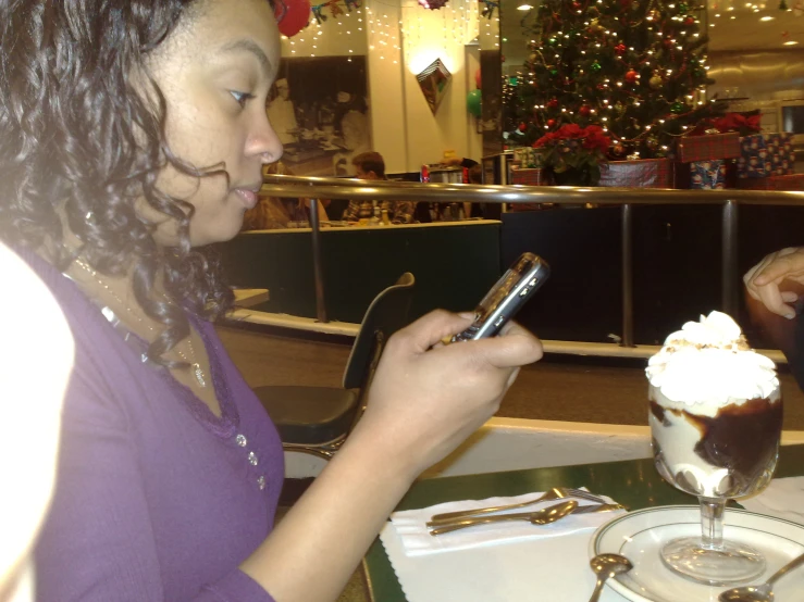 a young woman using her cell phone in a restaurant