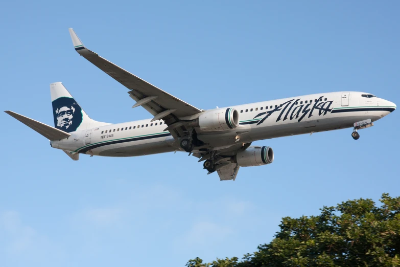 an airplane flying in the blue sky with its wheels off