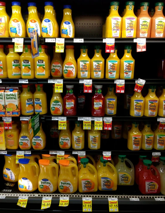 several rows of orange juice are on shelves