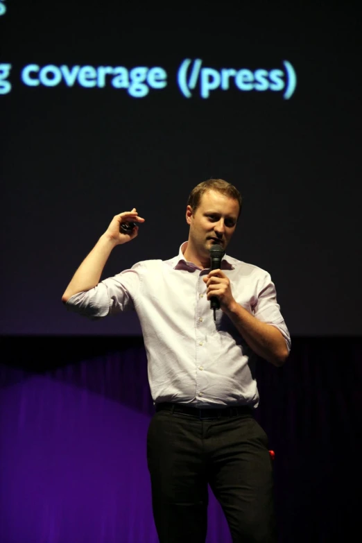 a man standing up on stage giving a talk