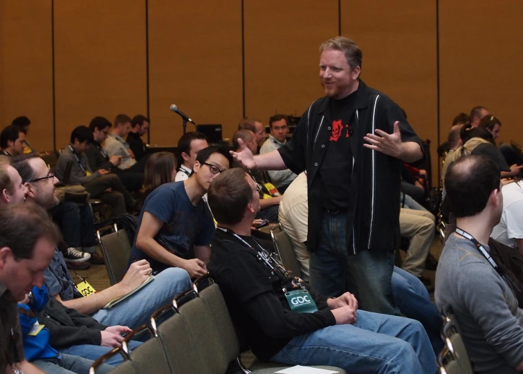 a man standing in front of an audience in a meeting