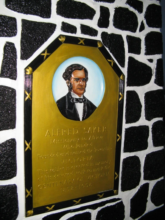 a plaque in the shape of a giraffe print with a picture of an african american politician is mounted on a brick wall