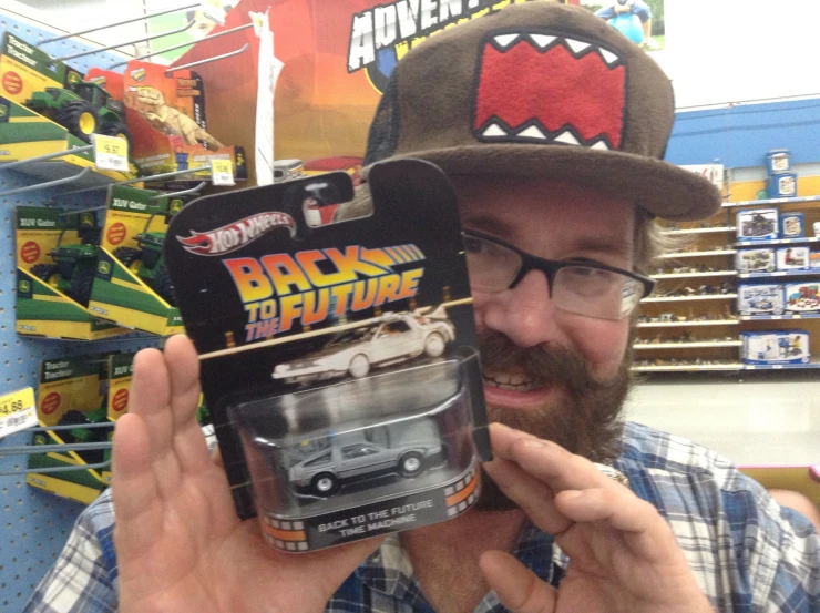 a man in a hat that is holding a toy car