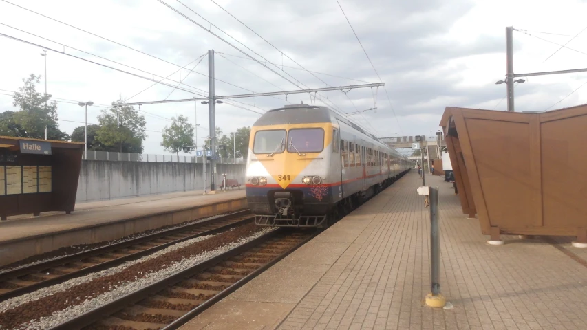 a train stopped at the empty platform in the rain