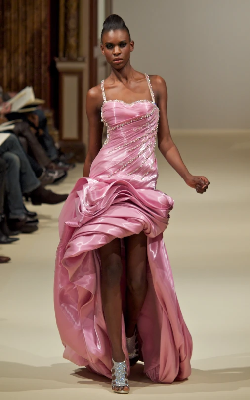 a model in pink is wearing a dress with a high slit