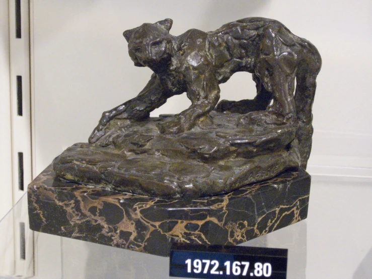 a bronze sculpture with a small sign on it