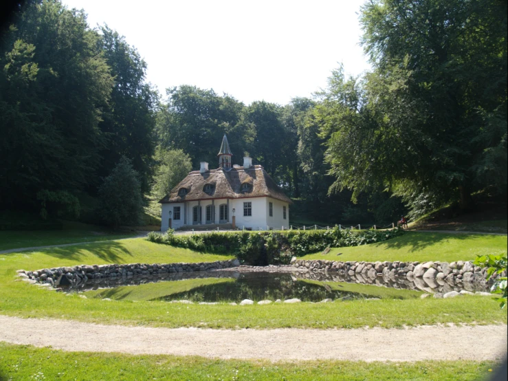 a white house surrounded by some trees in a park