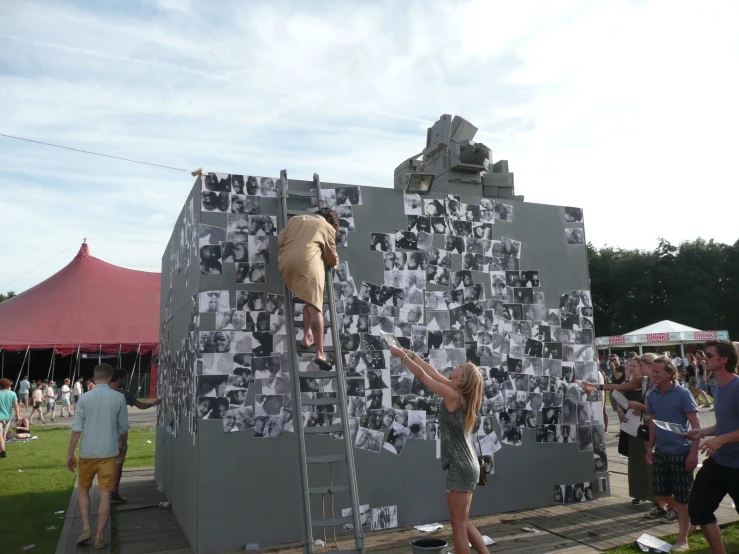 a woman standing on top of a metal platform next to a giant statue