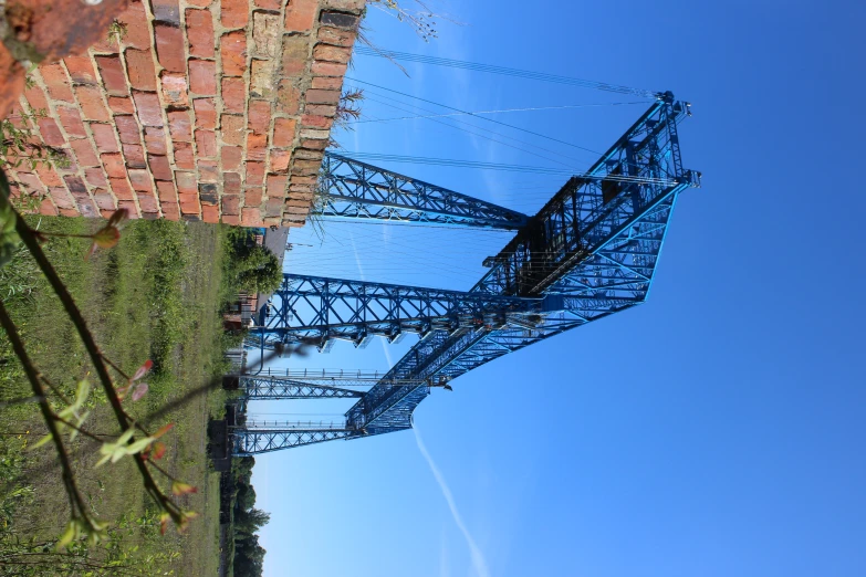 a large blue steel structure is behind a red brick wall