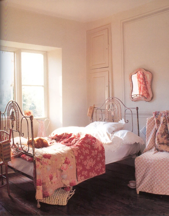 a bedroom with pink and orange bedding, a twin bed, and two little s beds