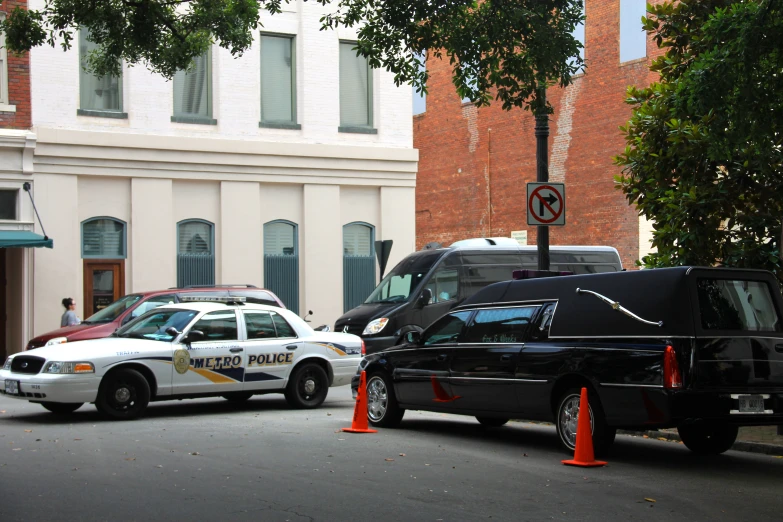 a city street with vehicles, police cars, and a building