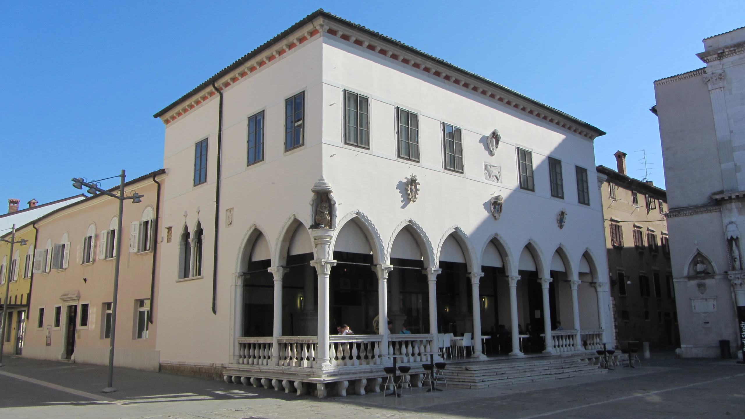 there is a white building that has arches and columns