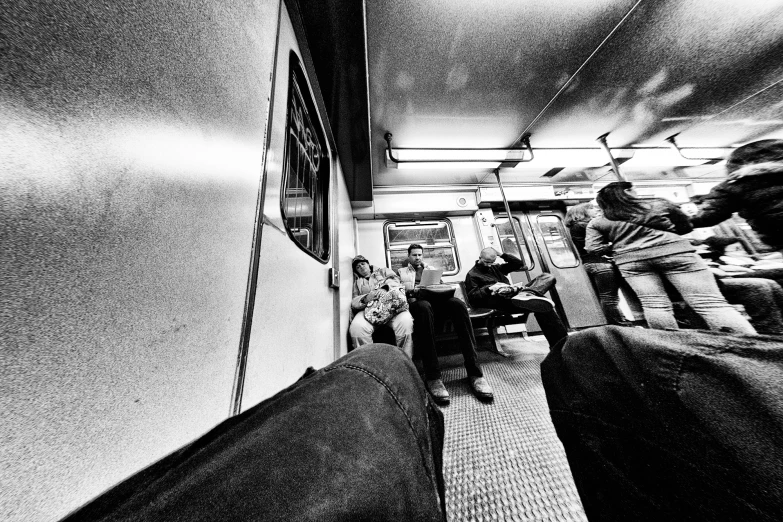 a black and white image of passengers on a train