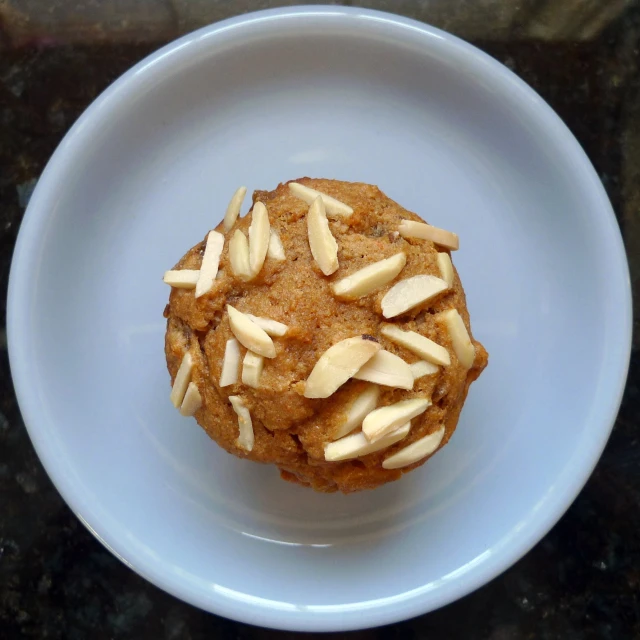 a muffin with almonds and cinnamon in it on a plate