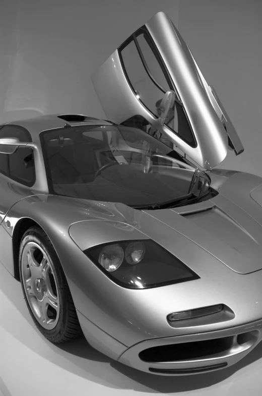 a silver sports car on display with the hood opened