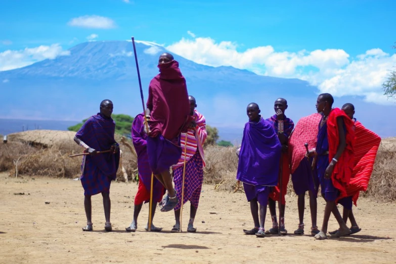 men in traditional clothes with mountains and clouds in the background