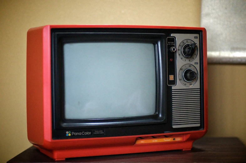 an old tv sitting on top of a brown table