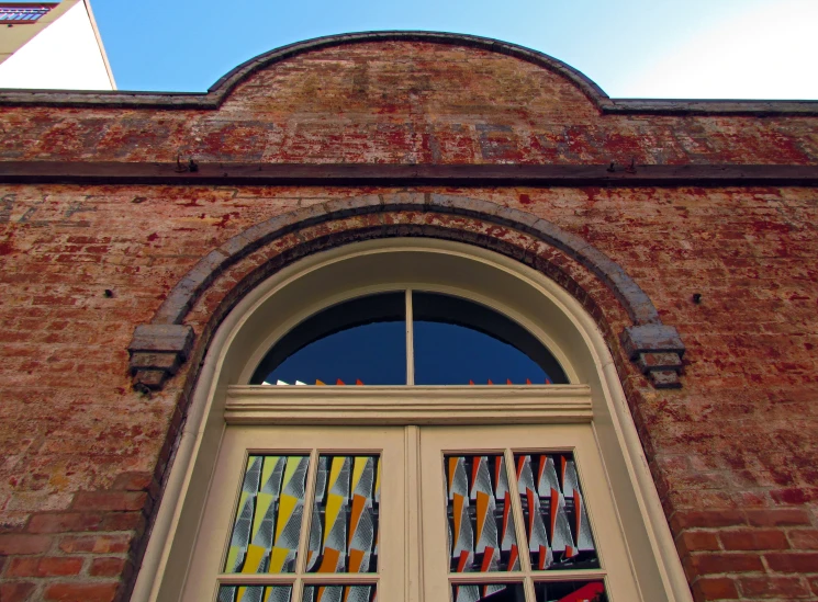 the window on a brick building has many items of color