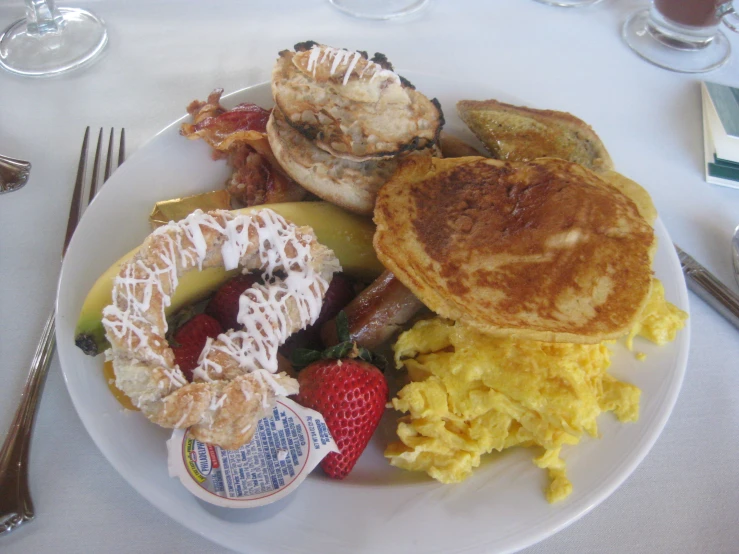 a white plate topped with breakfast food on top of a table