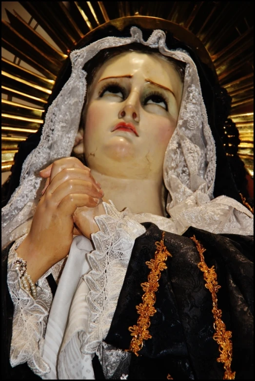 a statue that is dressed in a black dress and white lace