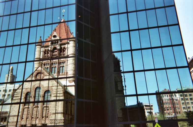 the reflection of an old cathedral in the windows of a building