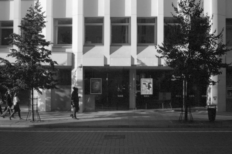 a black and white po of people walking on a city sidewalk