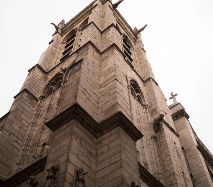 the side of a church with several birds on the cross