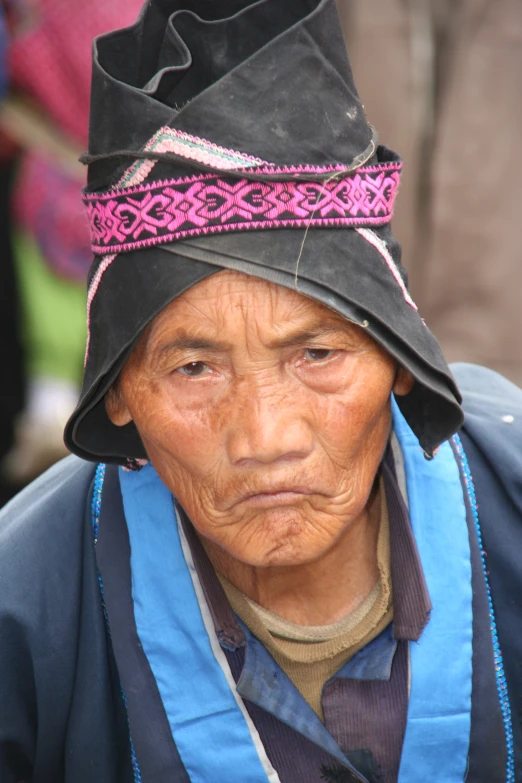 an older woman wearing a hat with a bright pink trim