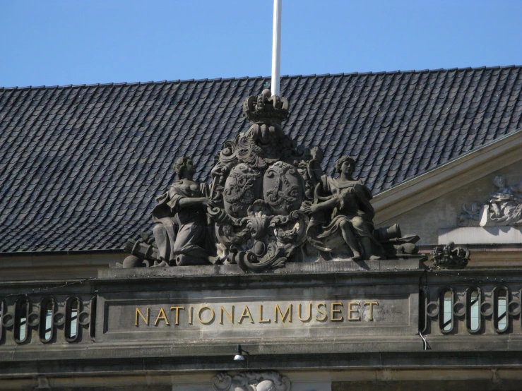 a clock tower with statues on top of it