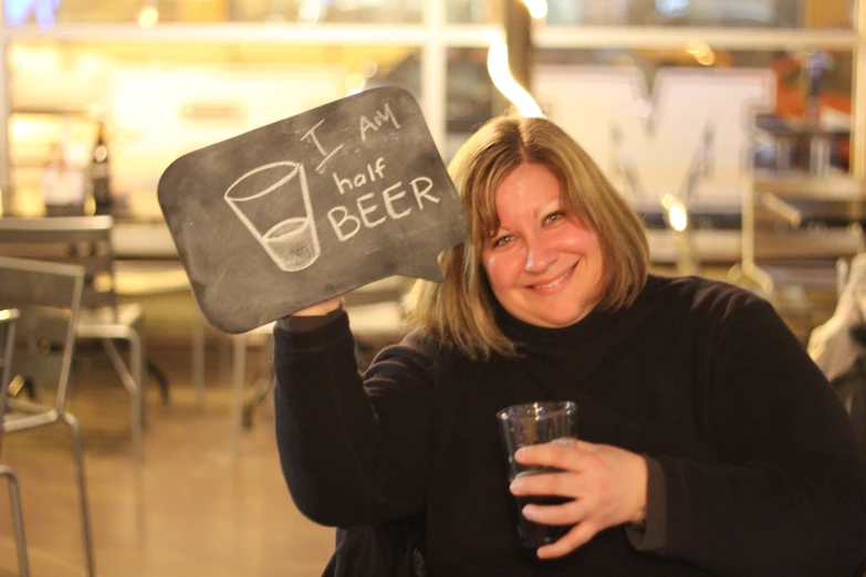 a lady holding up an advertit for craft beer