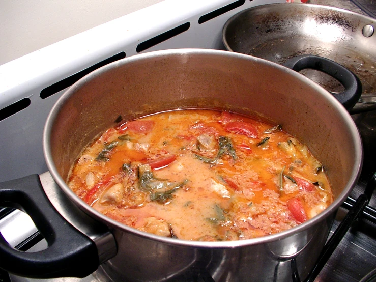a pot full of cooked vegetables and sauce sitting on the stove