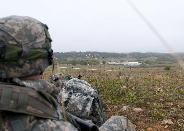 two military personnel are on the field with guns