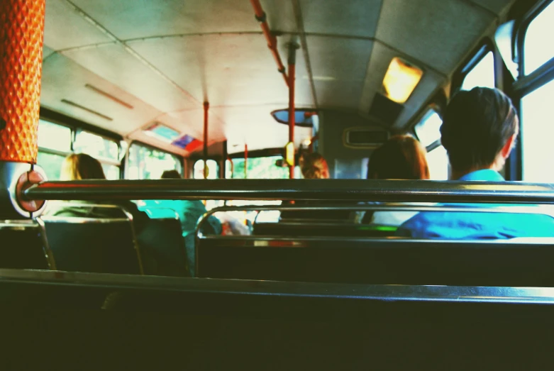 several people sit inside a public transit bus