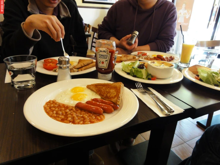 two people sitting at a table full of food