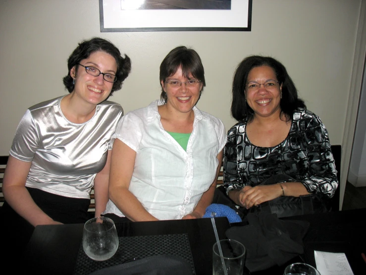 two women sitting next to each other in front of a framed picture