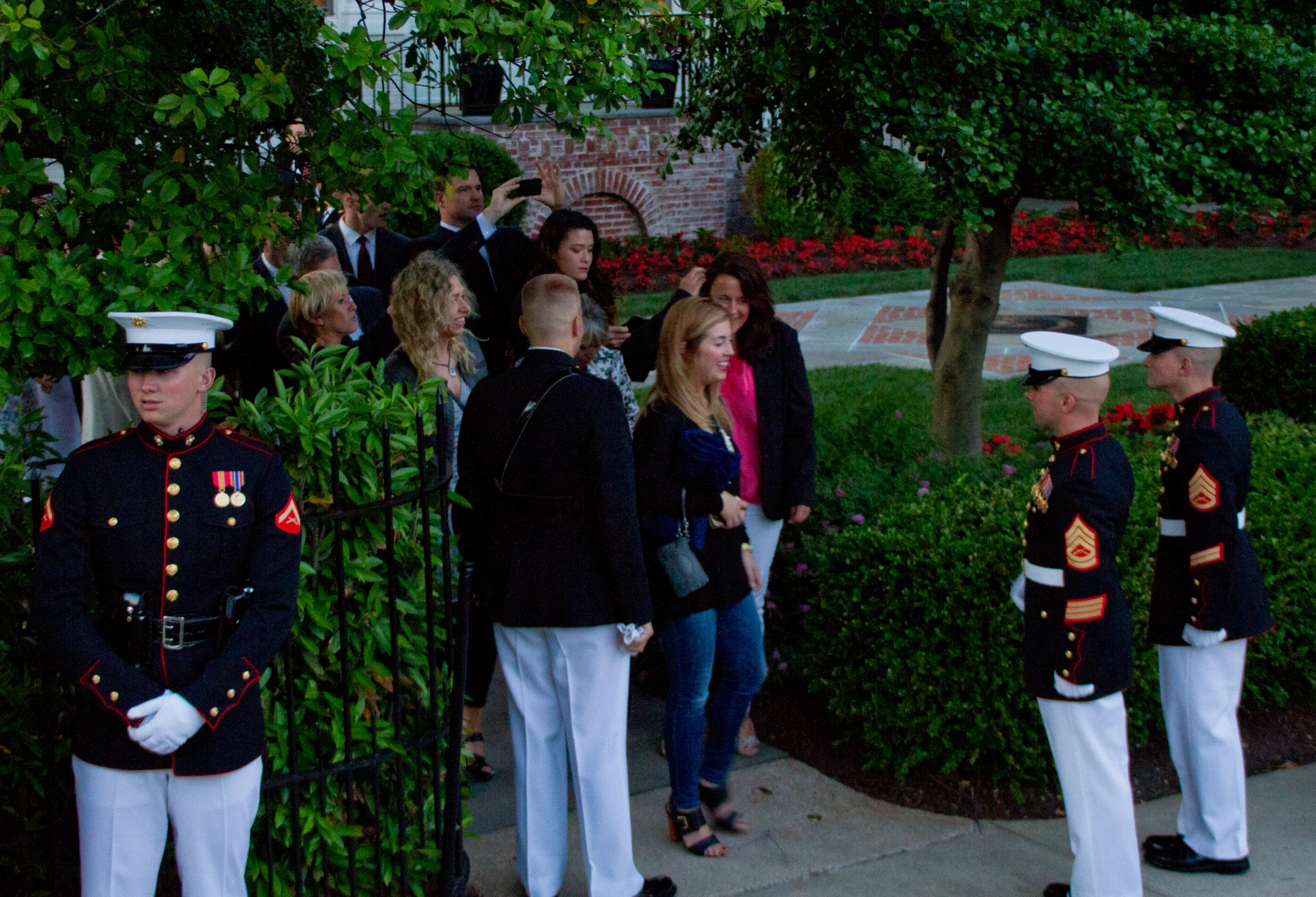 several people standing in line while a marine officer is saluting them